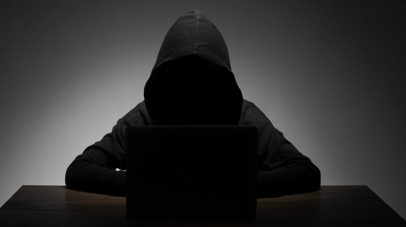 dark figure behind the computer