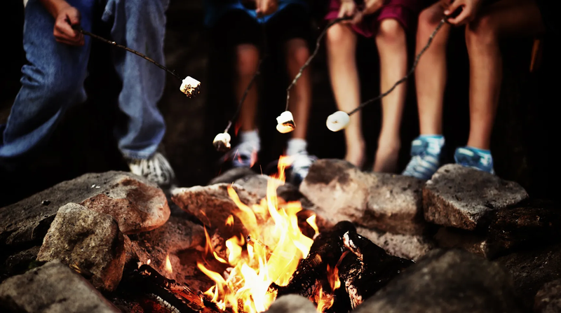 people roasting marshmallows over a campfire