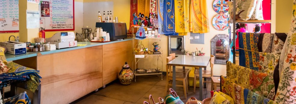 Imported world goods like blankets, dolls, and baskets line the walls near the cashier at High Desert Market and Cafe.