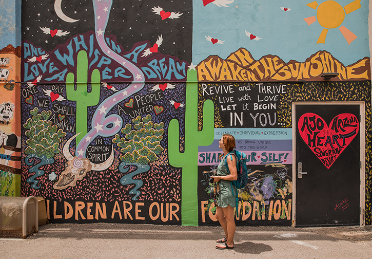 A woman in front of a cactus mural in Ajo Arizona