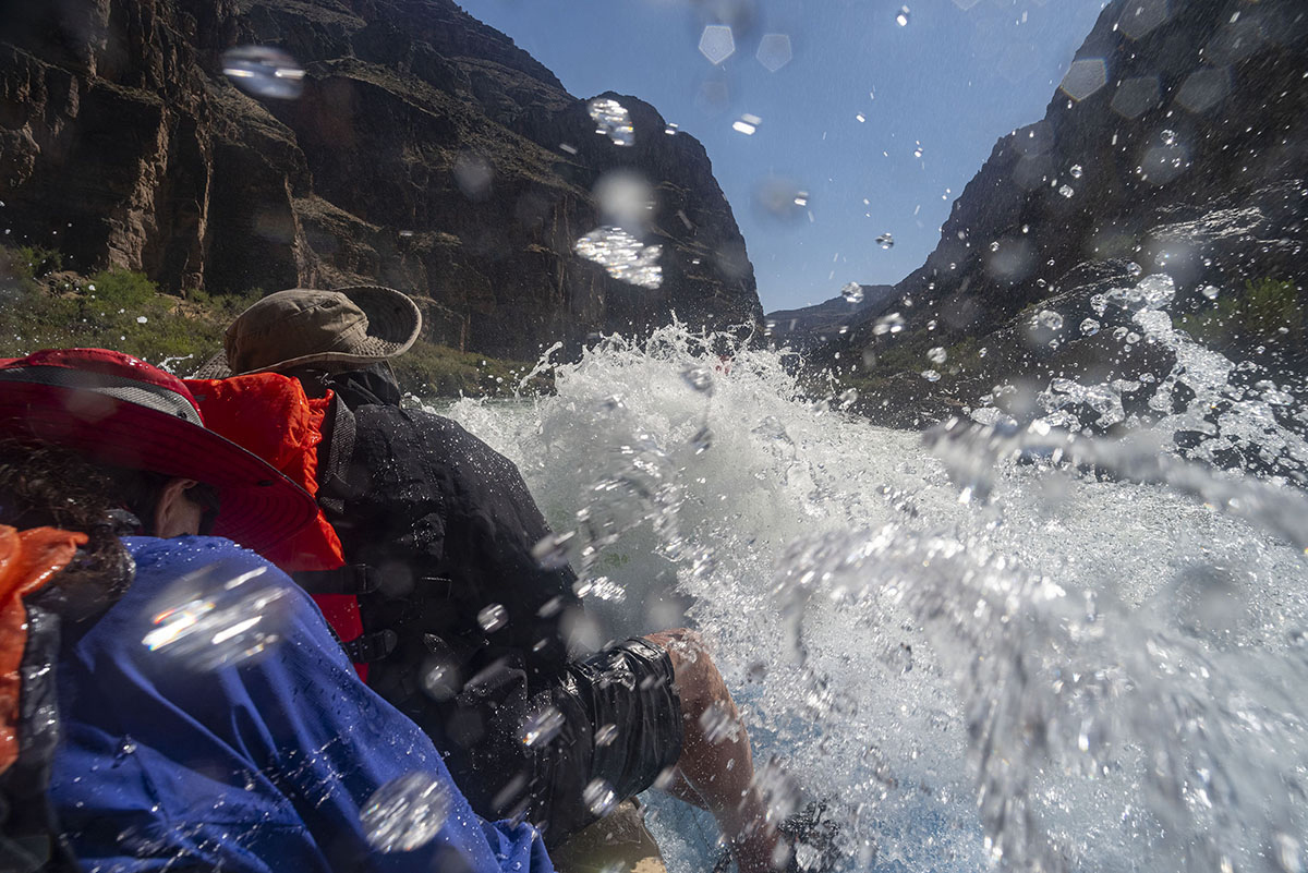 Rafters get wet as water splashes into their raft at Lava Falls Rapid (Class 10 Falls) in Grand Canyon National Park.