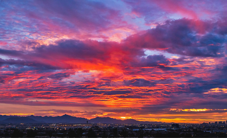 Purple, orange, pink and blue-hued clouds fill the sky at sunset over South Mountain in Phoenix