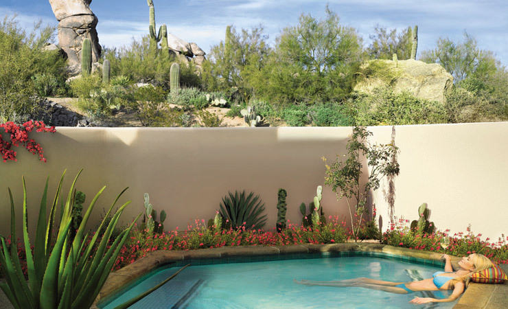 A woman lounges in a private pool in the desert.