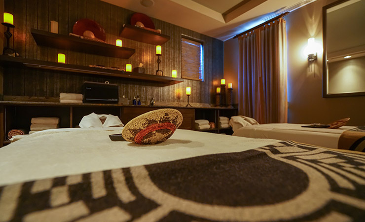 A warmly lit spa room with candles and American Indian decor