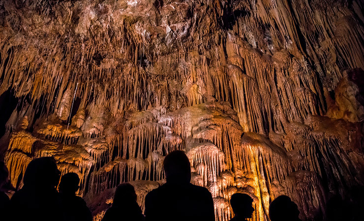 Silhouettes of people looking up at the caverns