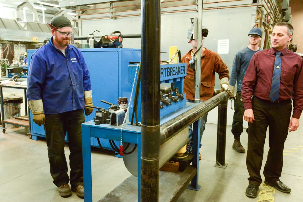 Dean Brian Haugen explains a weld failure pressure test to Surrey Board of Trade visitors to the welding lab.    Photo by Ray Hudson