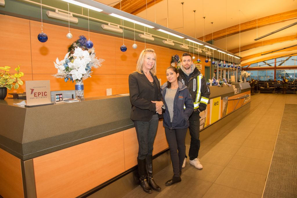 From left, Heather Braun, Airport General Manager, Safety Officer Navdeep Kaur and Brandon Walker-Shaw, Operations Supervisor stand by the ticket counter, decorated for the season. Photo: Ray Hudson