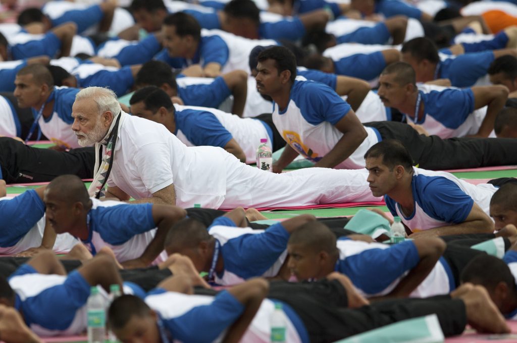 Indian Prime Minister Narendra Modi, center, performs yoga along with thousands of Indians in Chandigarh, India, Tuesday, June 21, 2016. Millions of yoga enthusiasts are bending their bodies in complex postures across India as they take part in a mass yoga program to mark the second International Yoga Day. (AP Photo/Saurabh Das)