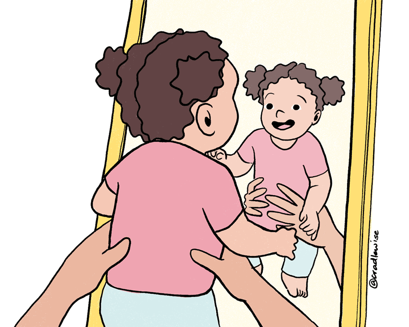 baby looking at themselves in the mirror