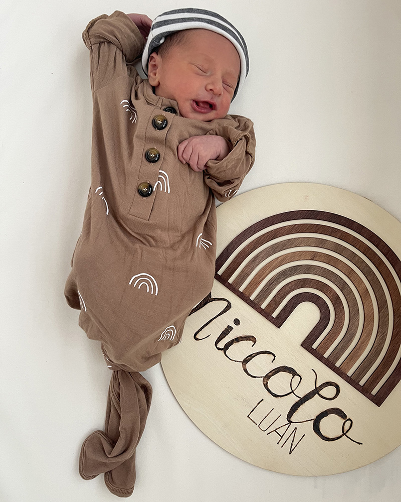 Newborn Niccolo Luan asleep next to sign with his name on it