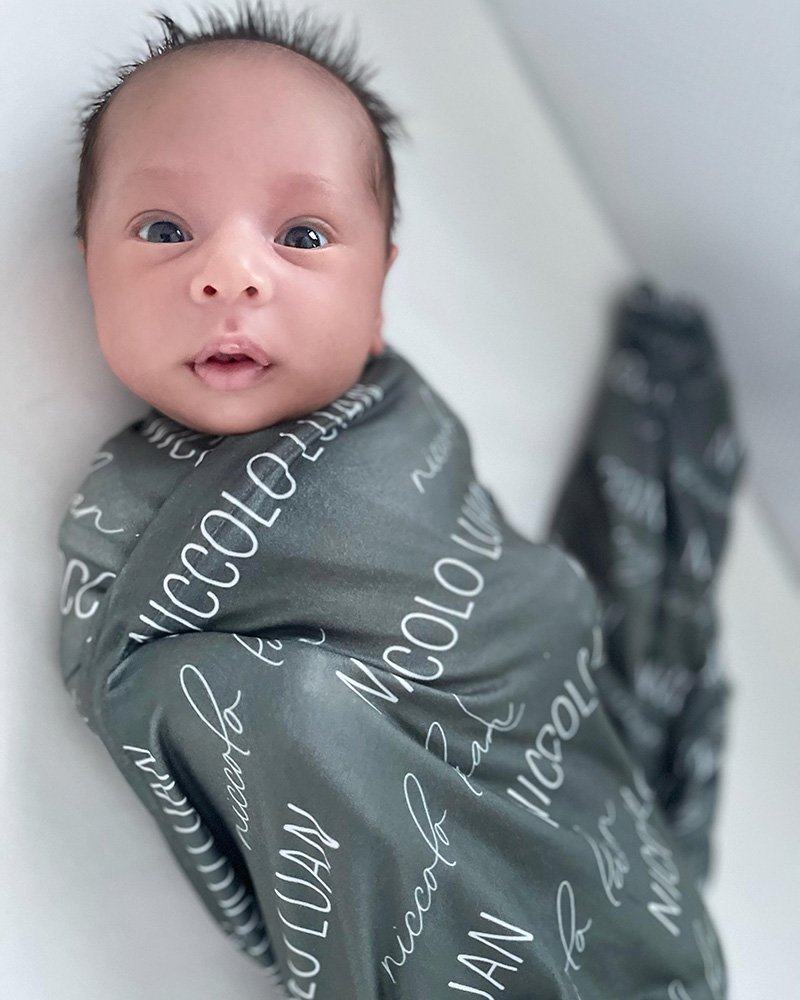 Baby Niccolo Luan swaddled in a green blanket