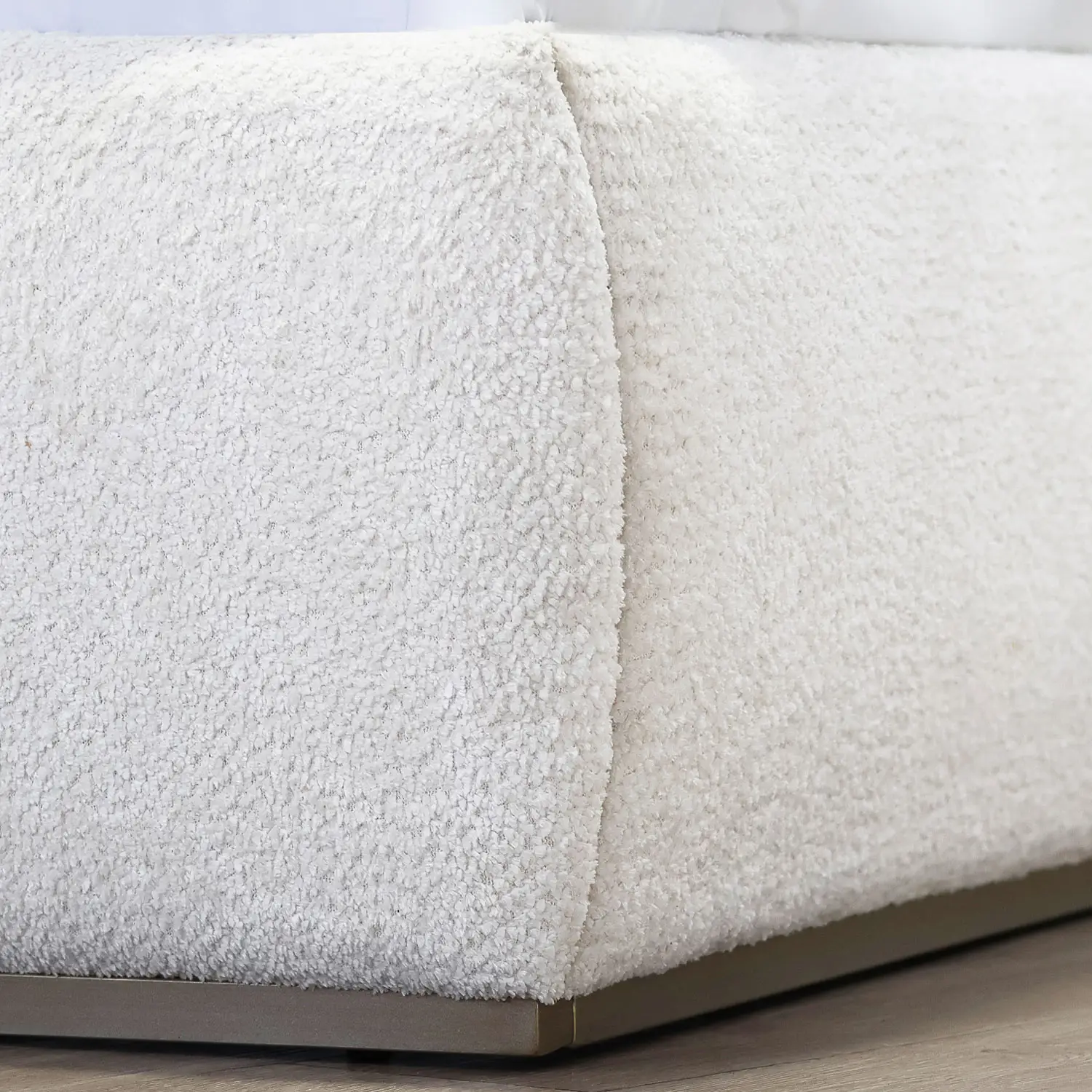 Beth 1349 Upholseted bed shown in Hand Brushed Copper Bliss finish with Cloud White Performance fabric. Close up of the footboard corner.