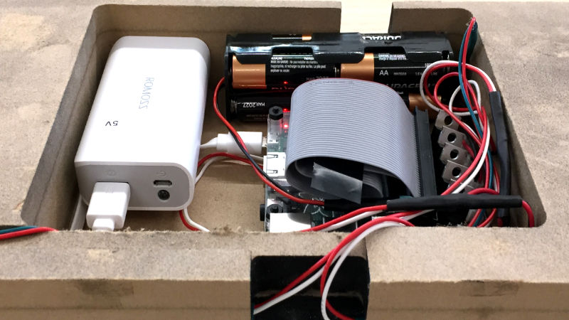 raspberry pi hardware, batteries and wires inside wood container