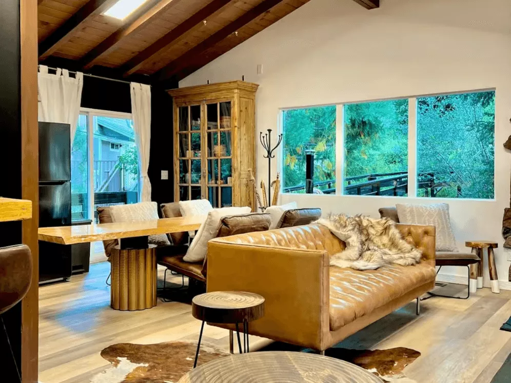 A photo of the Moonridge Cabin in Big Bear - there is a leather couch and leather angled dining chairs around a square table.