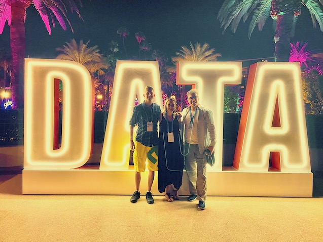 DATA sign lighted up bright gold lights with 3 people