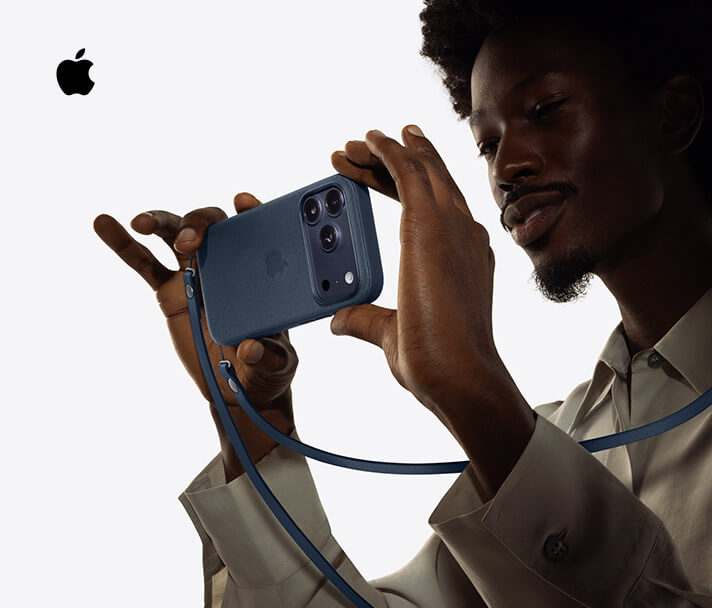 Person holding Phone 17 Pro to take a horizonal photograph, Deep Blue color, with Crossbody Strap around their shoulder