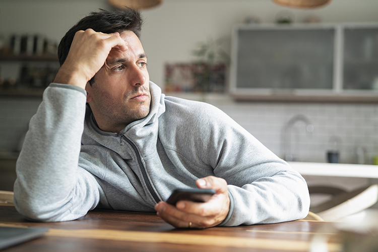 Handsome man in a sweatshirt feeling dissatisfied with his life