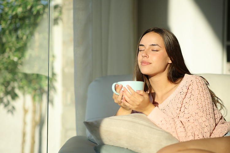 Picture of a pretty Latina sitting on a sunny couch with a cup of tea