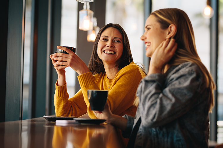 Two Young Women Chatting Happliy at a Cafe