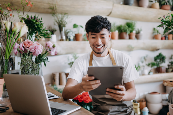 Young Latino smiling as he learns online how to care for the plants around him