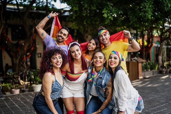 A group of young latin and hispanic men and women posing for a LGB pride photo