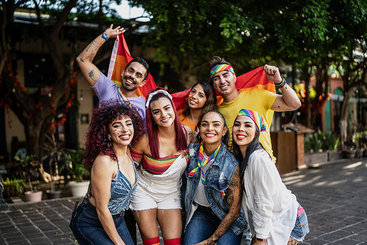 A group of young latin and hispanic men and women posing for a LGB pride photo