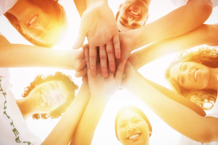 Group Of Volunteers With Hands In Center