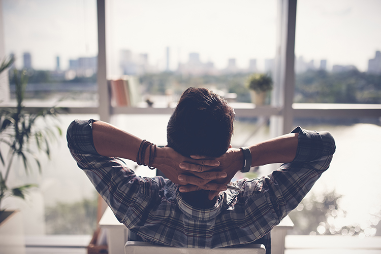 Man With Arms Behind Head Relaxing In Chair