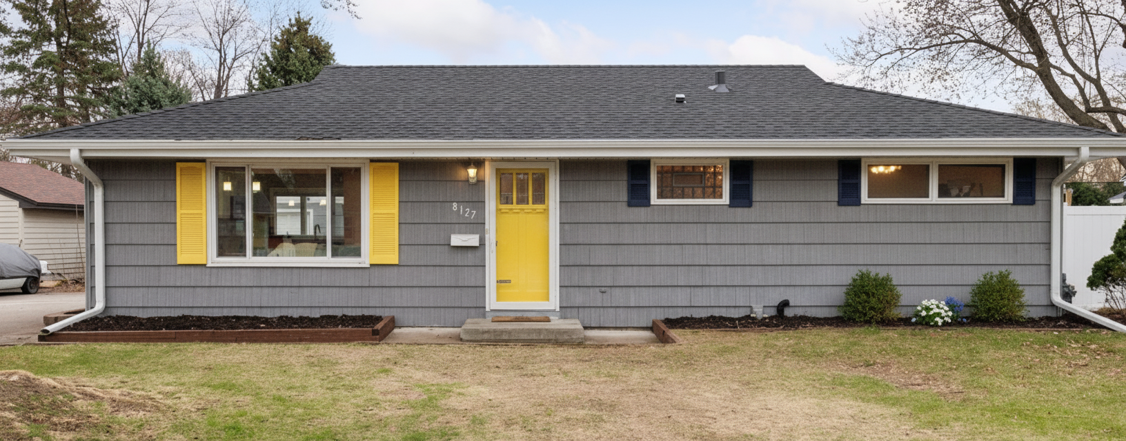 After - exterior transformation: Design type: exterior. Style Ref: None. Instructions: I would like to change the shutters to darker color. Maybe navy or black or dark grey. Also add shutters on the sides of the small windows where there currently is none. Also add some small landscaping on the right side of the door and remove the bench that is currently there.