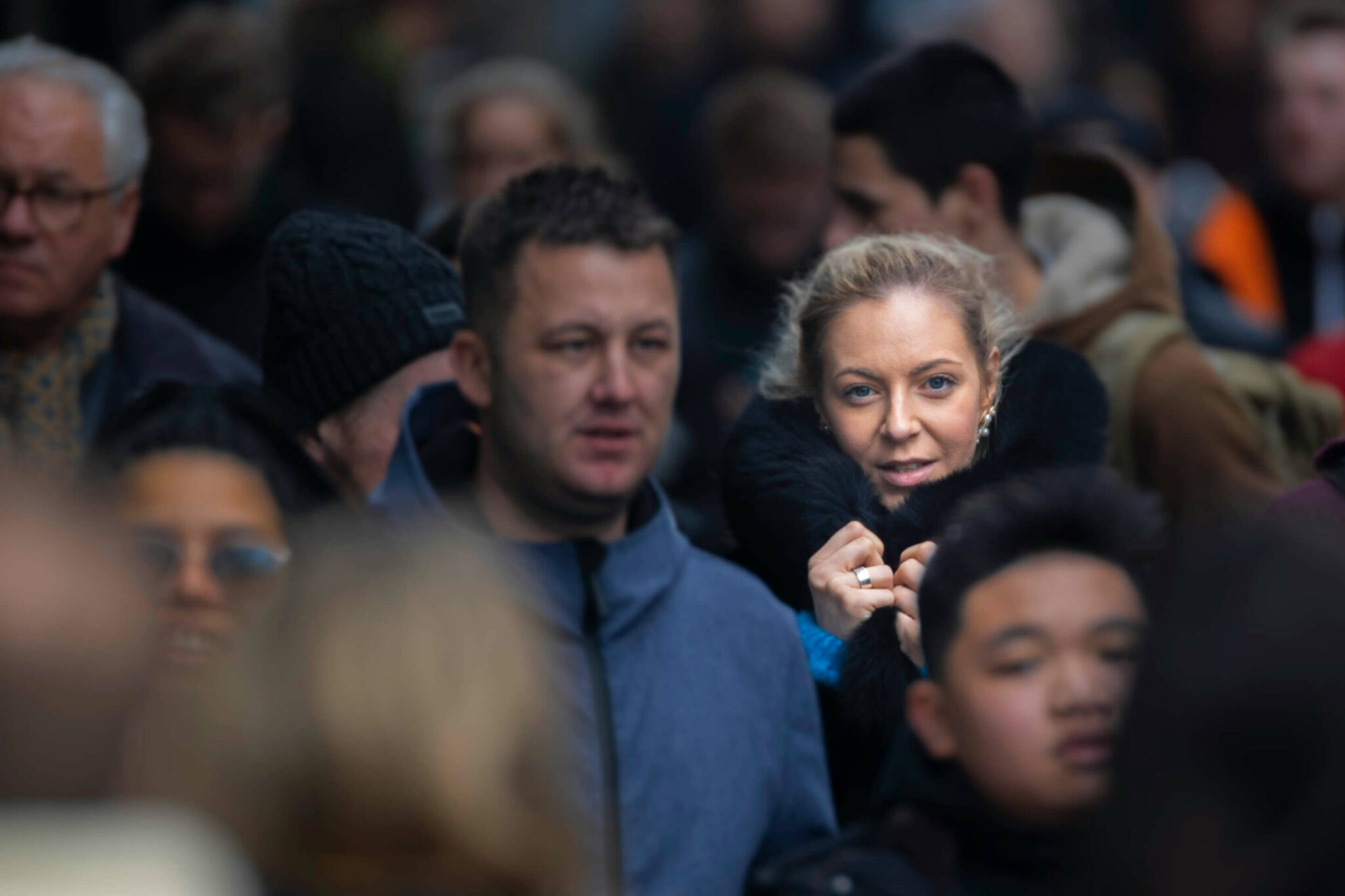 A crowd of people walking with woman highlighted as the target audience persona in the crowd.