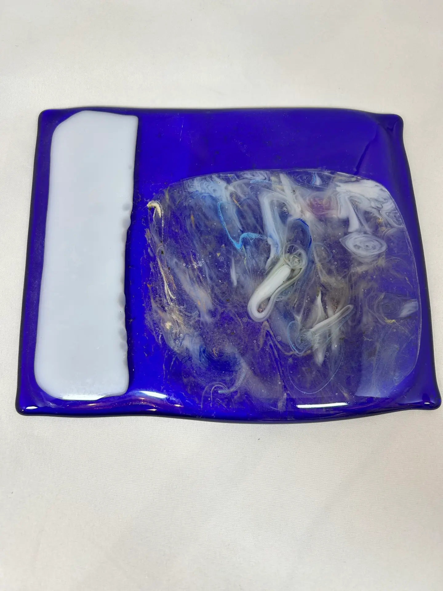 The Cosmic Drift, a blue glass rectangular plate featuring abstract patterns and a vertical white strip on the left.