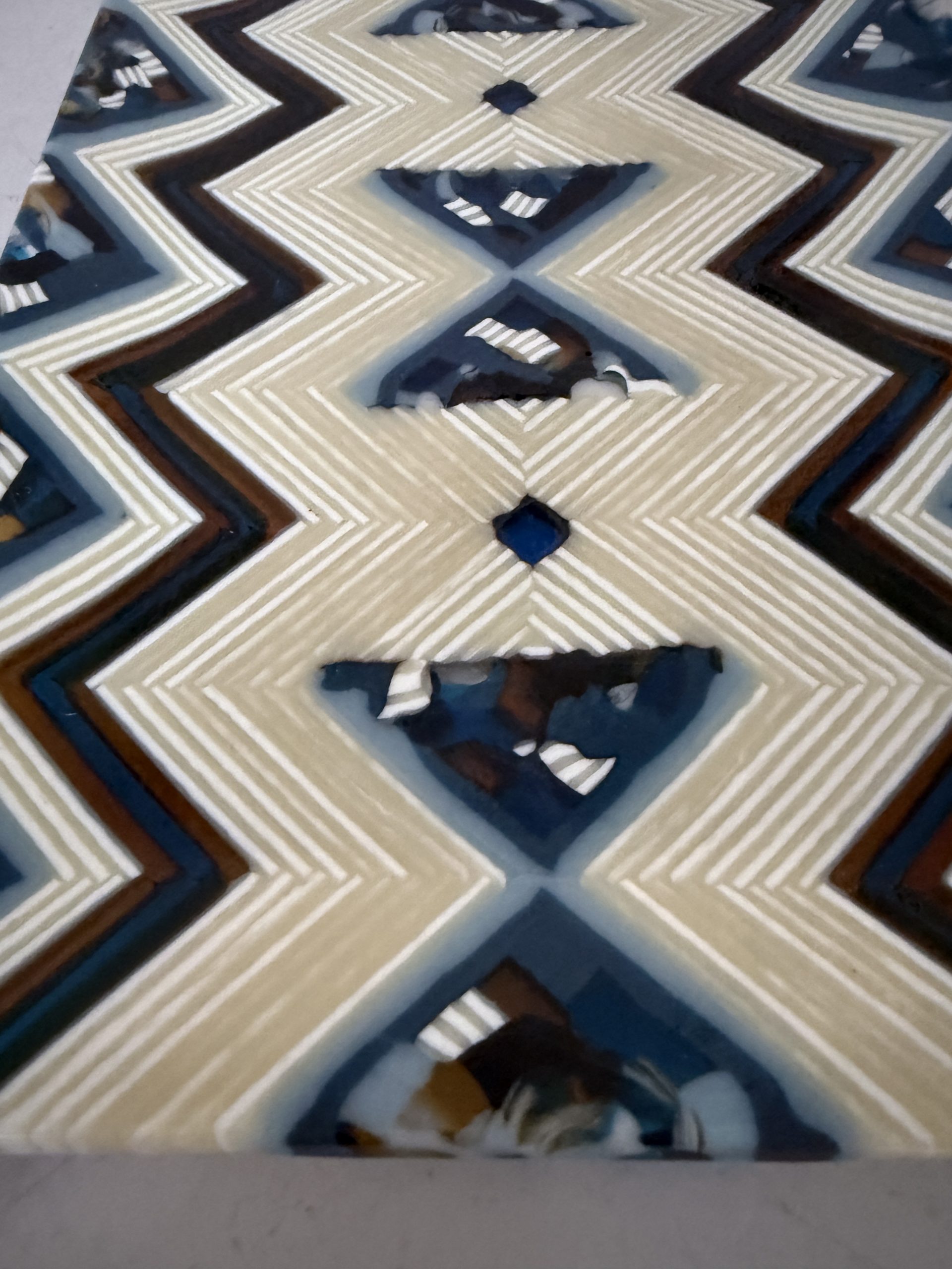Fused glass art panel by Patty Heinen featuring intricate on-the-edge pattern bars with cream, blue, amber, and charcoal zig-zag designs.