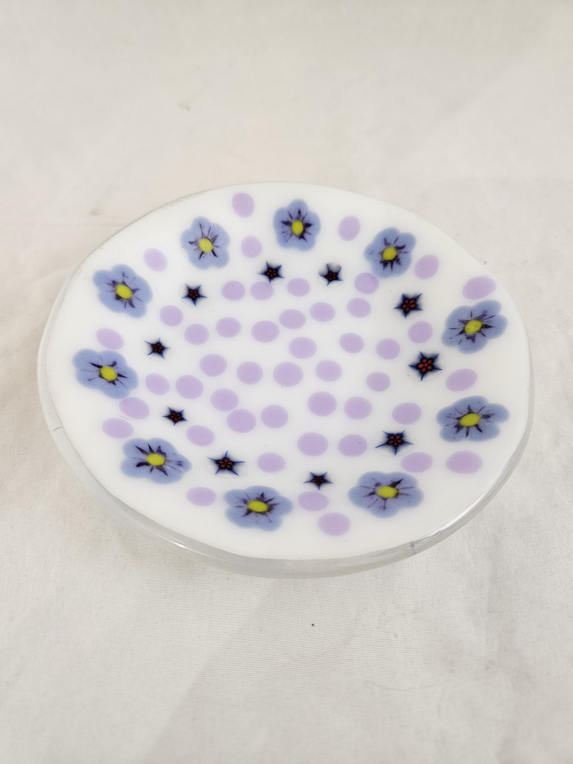 Petal Scatter small glass dish by Pat Spears with lavender dots and delicate flowers across white glass
