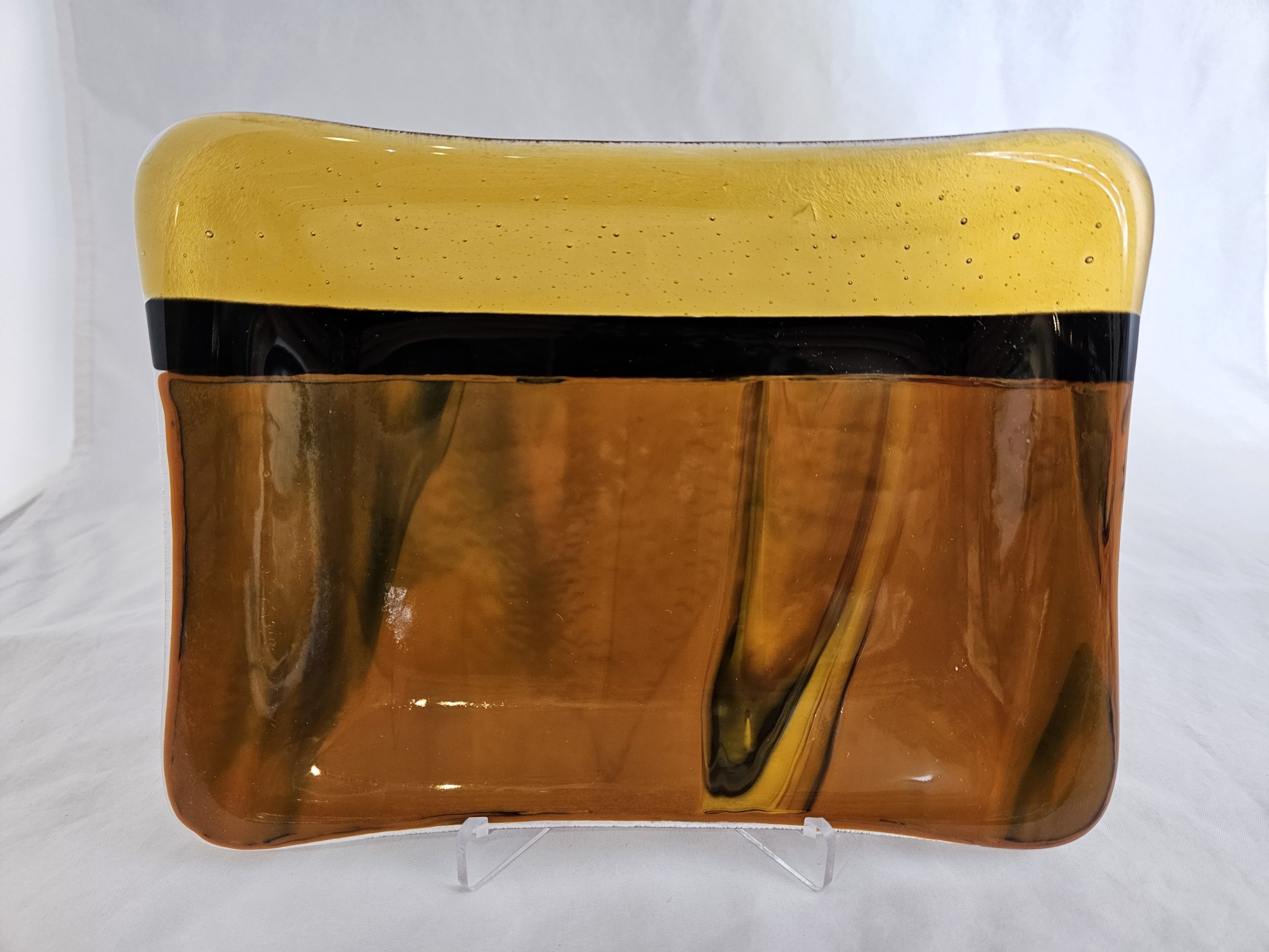 Contemporary amber fused glass plate by Nancy Dillingham Marks with flowing black accents
