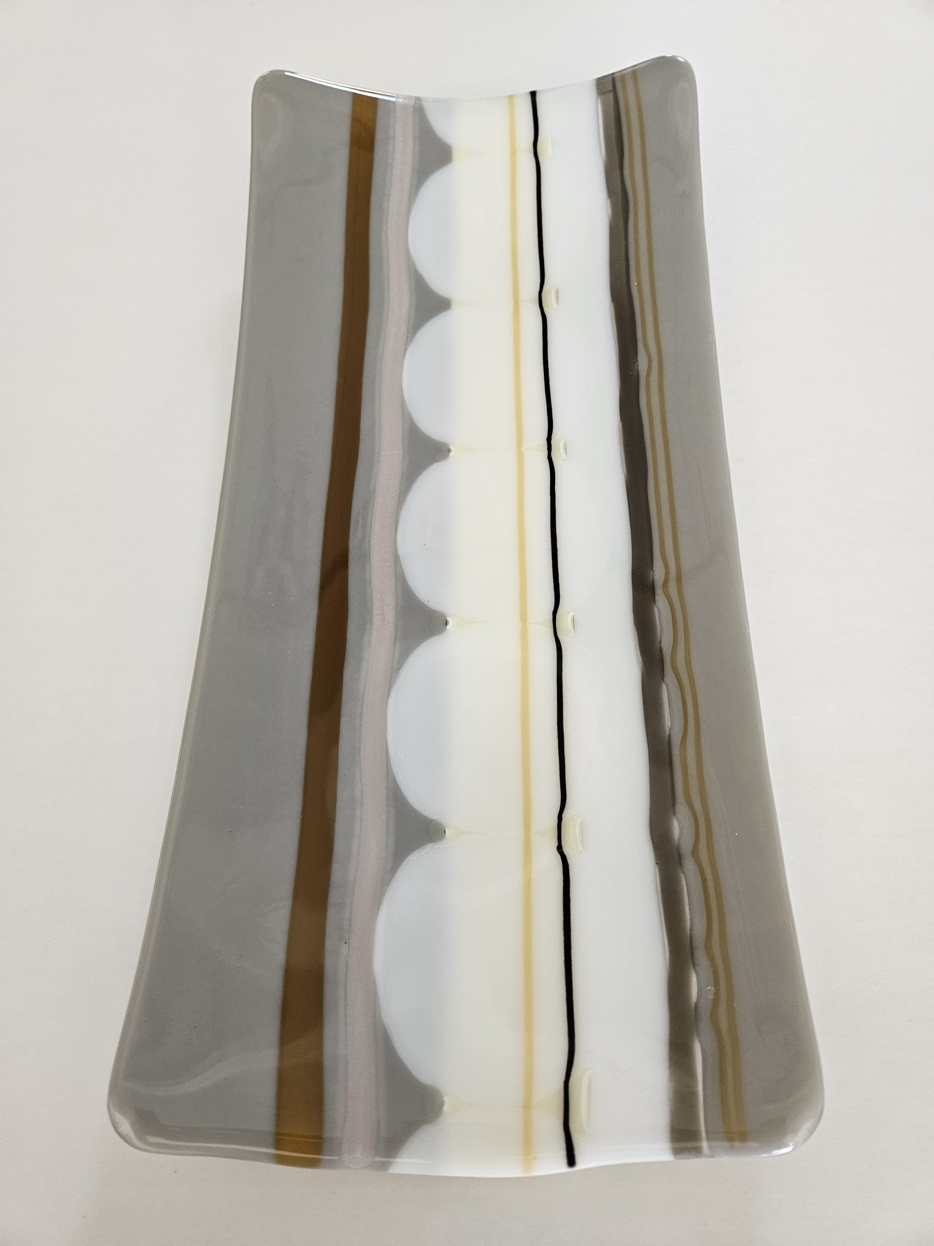 Neutral-toned fused glass serving tray with contemporary striped composition
