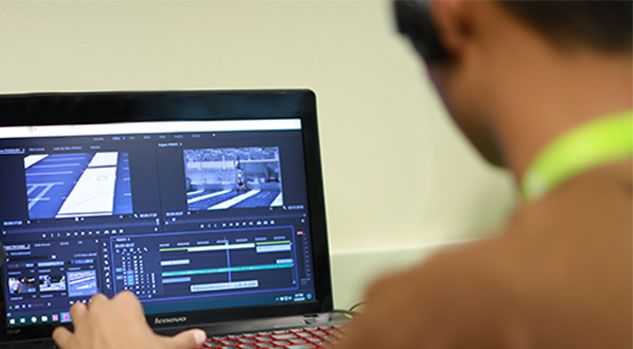 boy working on video production project on laptop