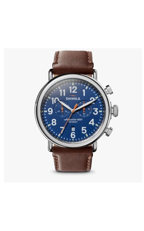 Shinola chronograph watch from the runwell collection, with a round blue dial, orange accents, and date, with a silver frame on a brown leather strap. Serial # S01 001 15880