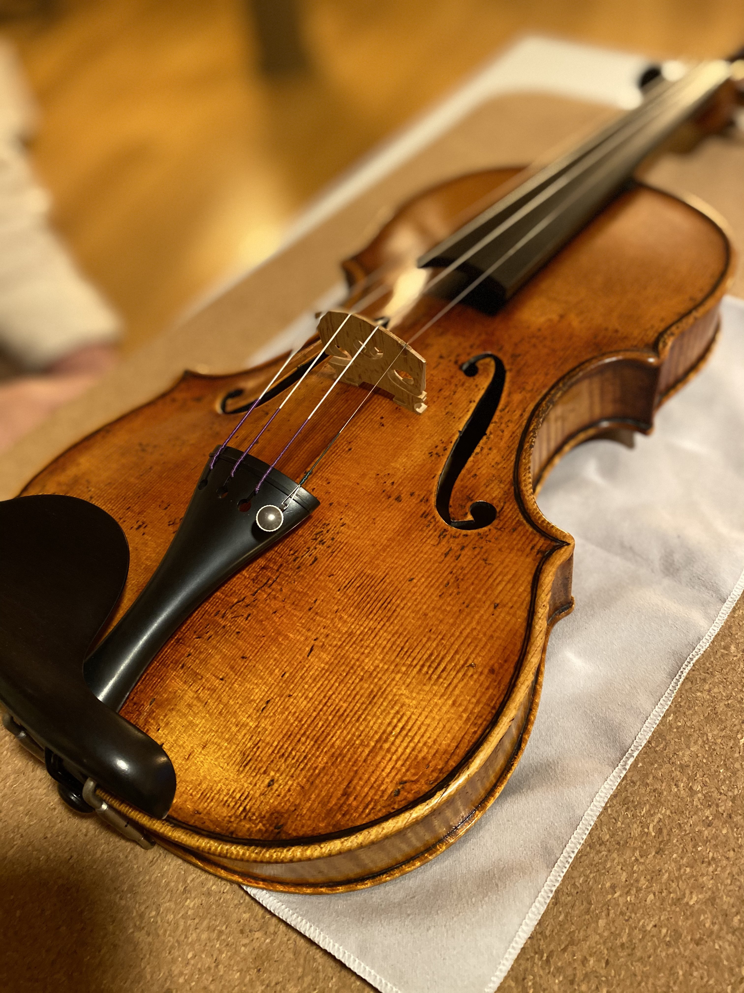 A handcrafted violin on a table by Mio Cannone Violini