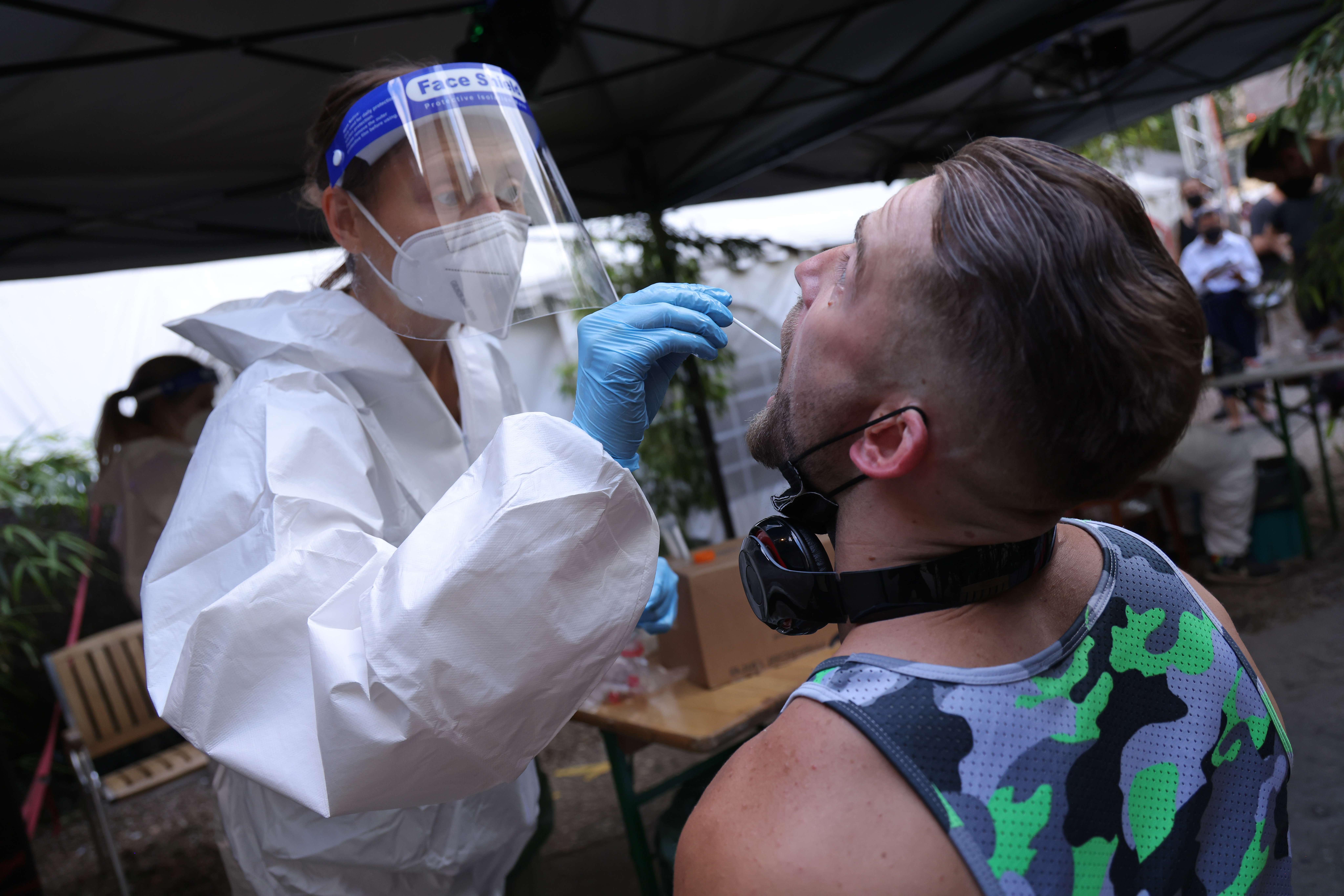 A participant submits for an express PCR test for Covid-19 outside the KiKat Club prior to taking part in an experimental, limited opening of Berlin nightclubs, Aug. 6.