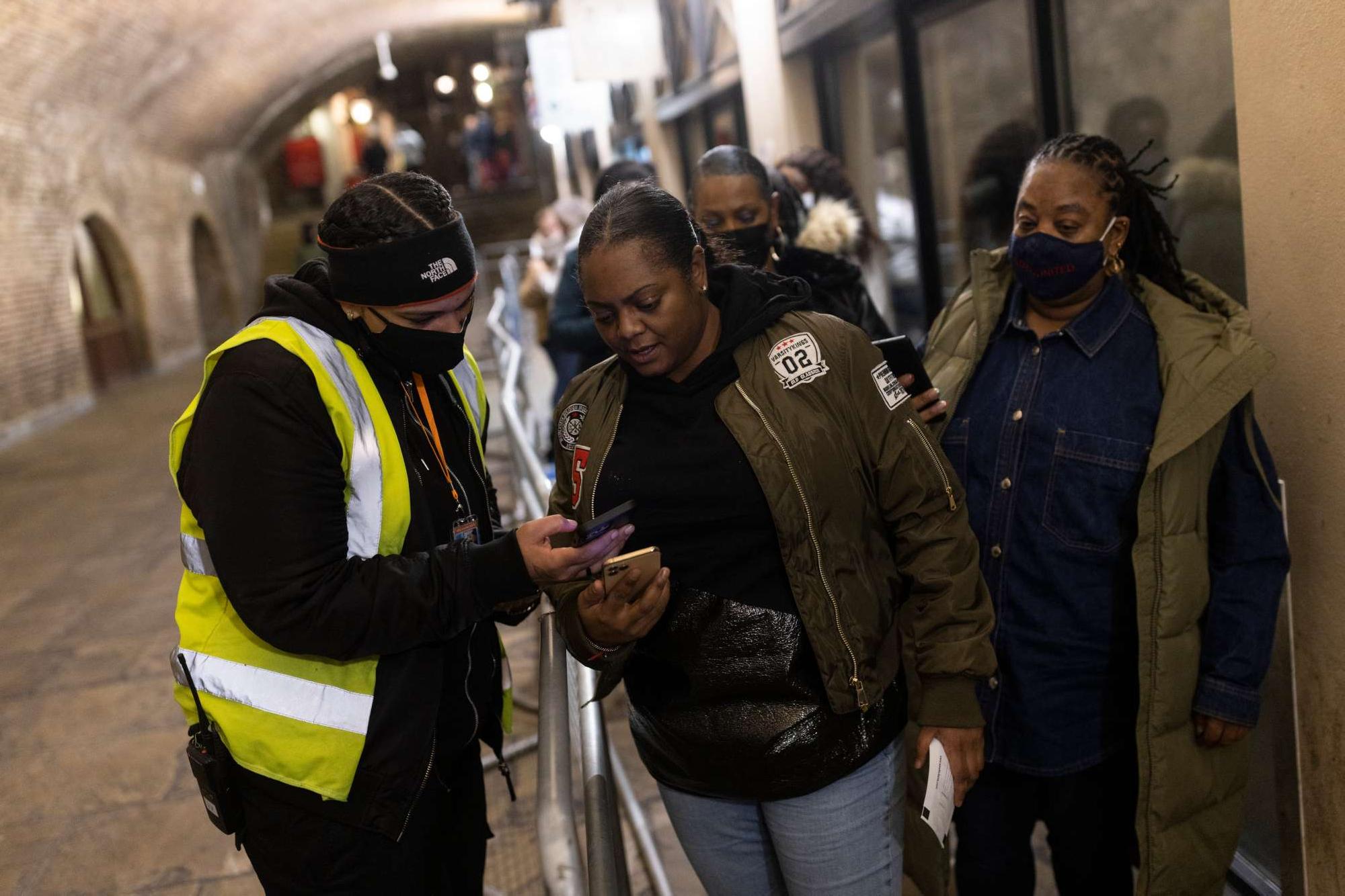 Visitors display their COVID vaccination passes as they arrive at Heaven nightclub ahead of a performance by the House Gospel Choir, Dec. 15, 2021 in London, UK. 