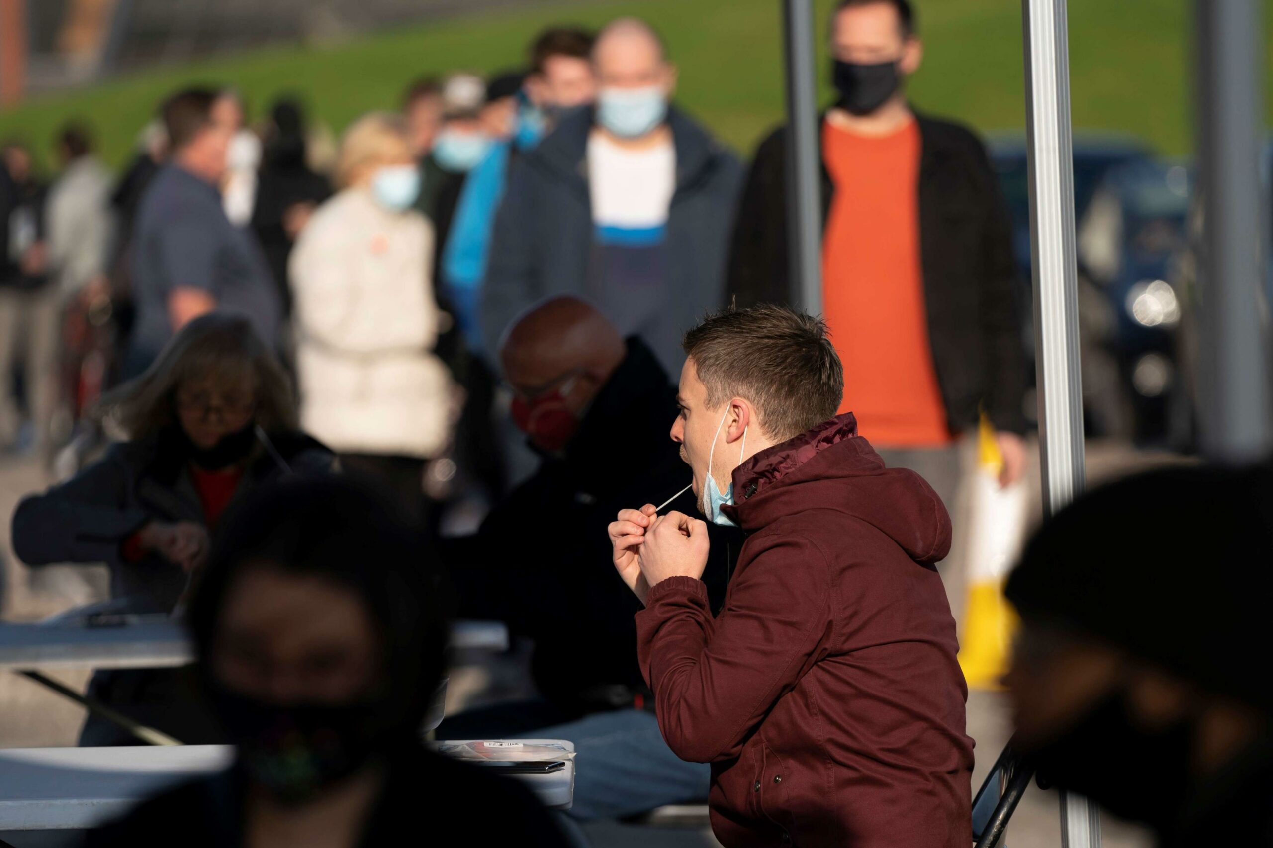 A man collects a swab by himself at a COVID-19 testing center in Liverpool, England, Nov. 6, 2020. 