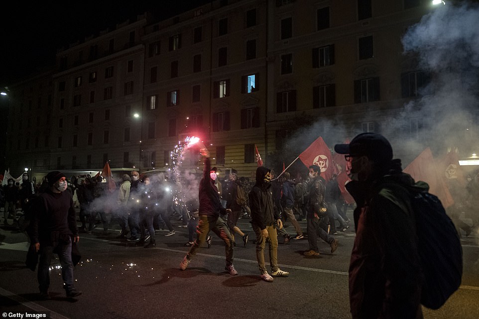 Anti-lockdown demonstrations intensified around Europe on Saturday night as protesters in Rome hurled Molotov cocktails, bottles and rocks at police and there were also rising tensions in Barcelona and Berlin. Pictured: Protesters in Rome, Italy