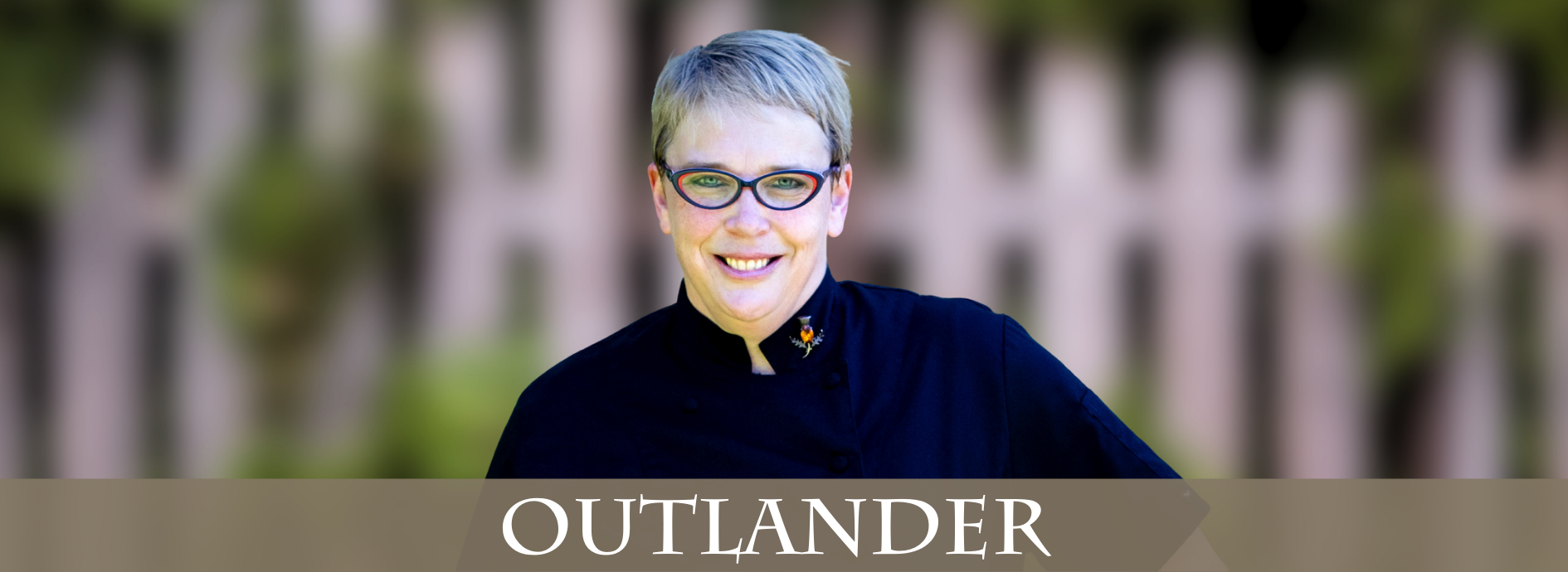 woman with short hair and black glasses, wearing a black chef's jacket