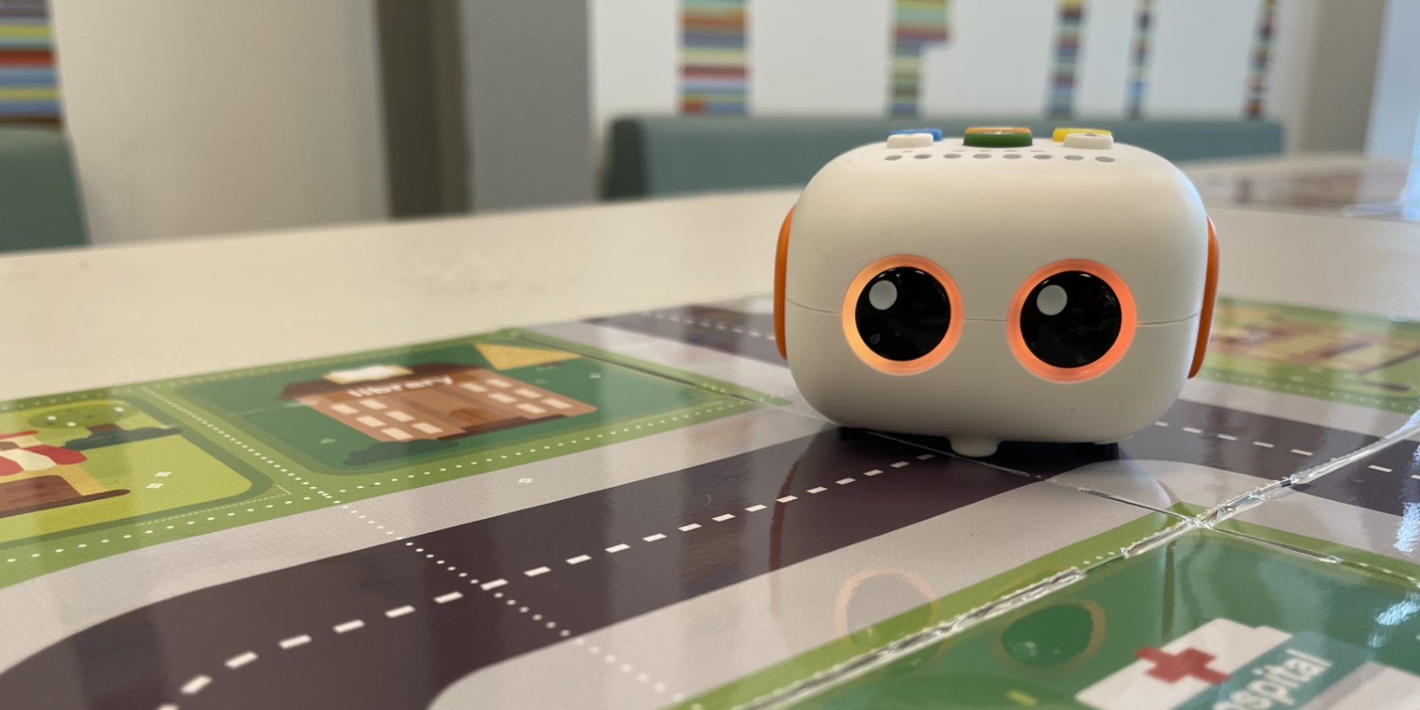 white cube robot with orange glowing eyes on city map