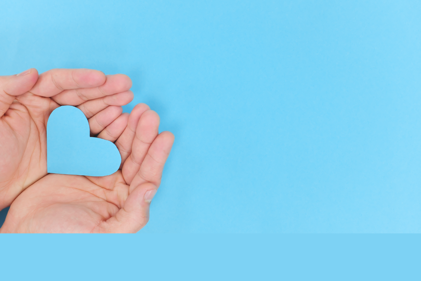 light blue background with cupped hands holding a light blue heart
