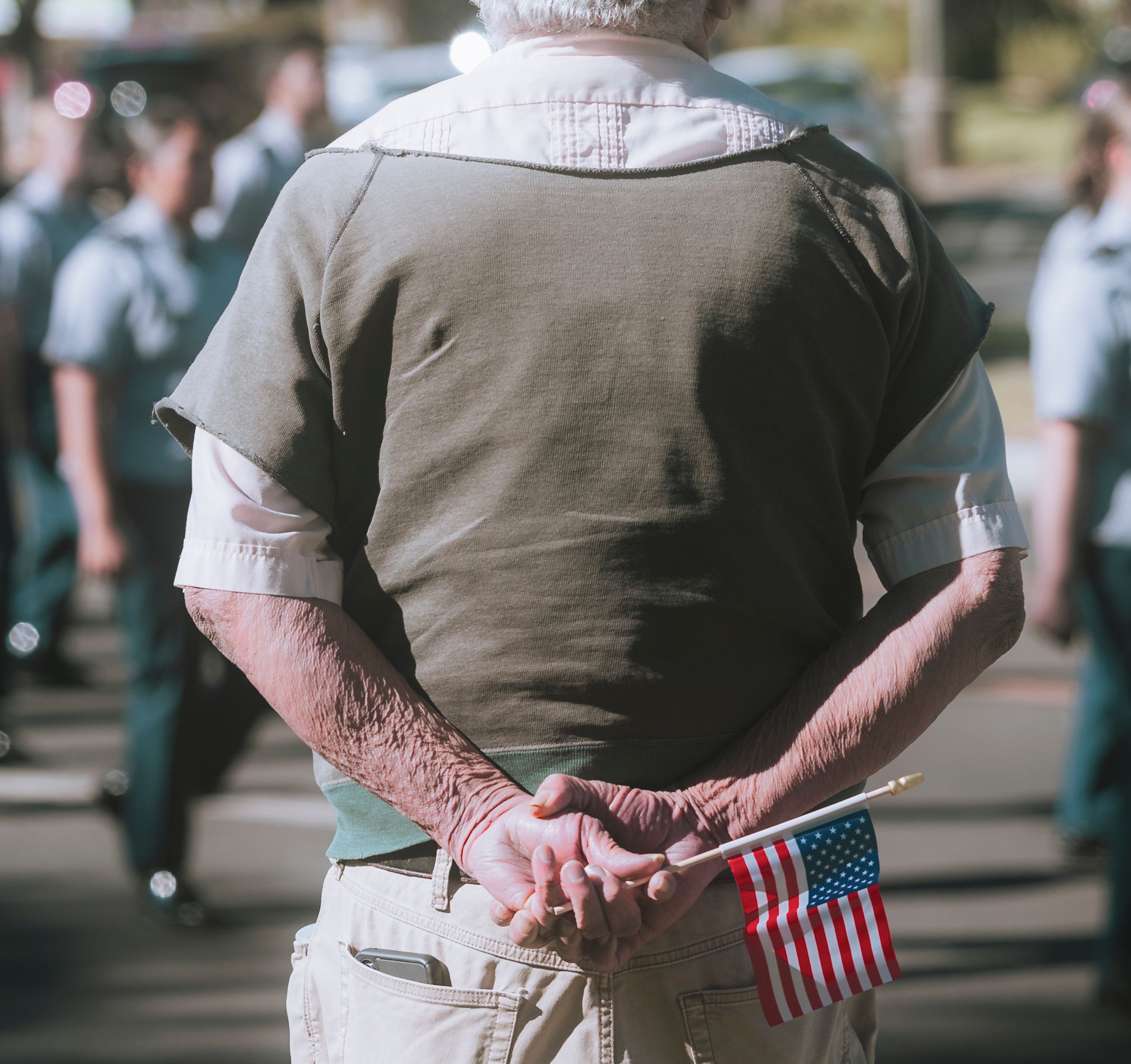 older elderly man holding flag