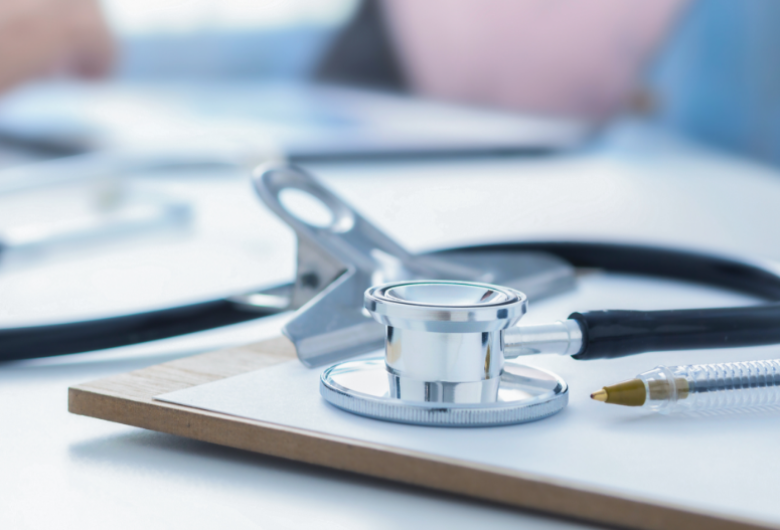 Stethoscope and clip board on the doctor workplace close up