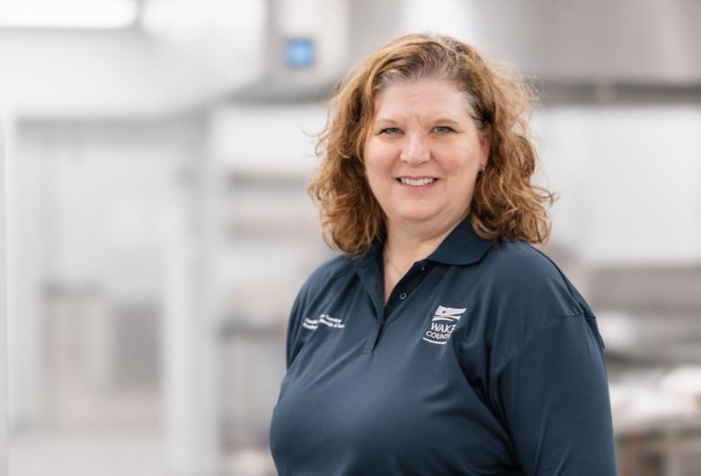 smiling woman stands in front of building