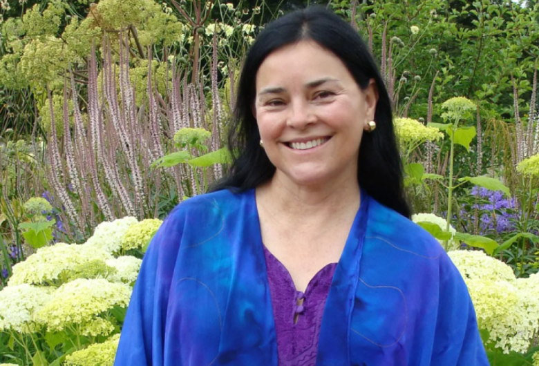 smiling woman standing in flower garden