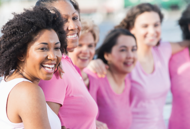 Diverse group of women wearing pink and smiling 